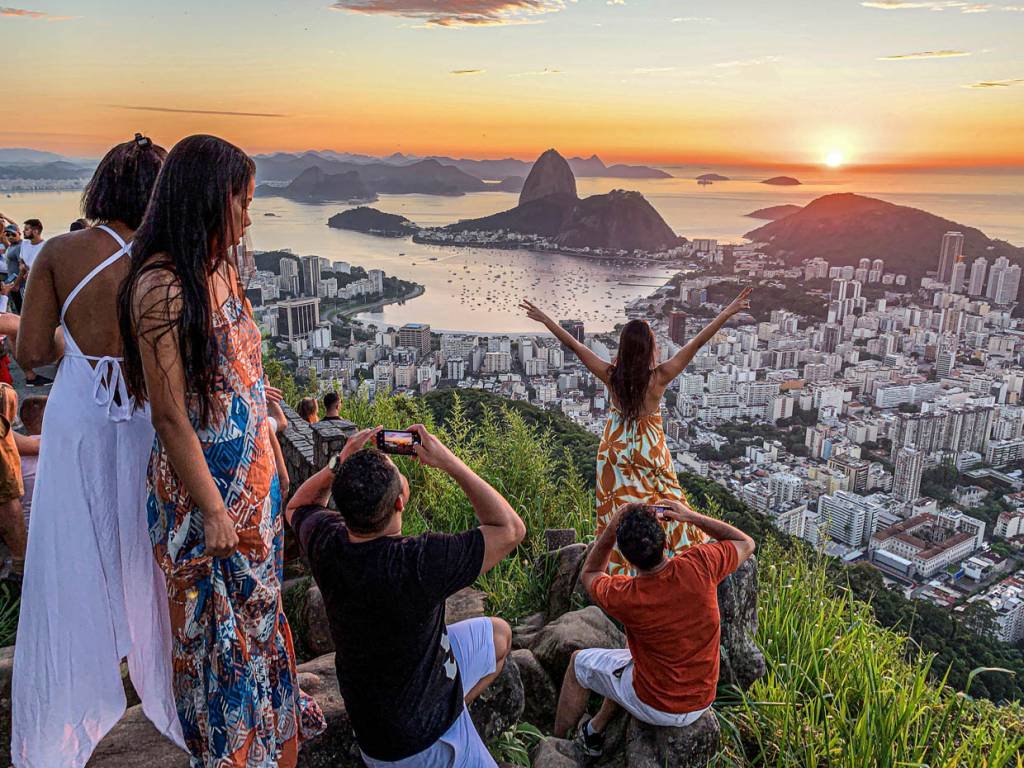 Sunrise from Dona Marta lookout, with Sugarloaf mountain in the background, in Rio de Janeiro As pessoas aproveitam o nascer do sol no mirante Dona Marta, com o Pão de Açúcar ao fundo, em meio ao surto da doença do coronavírus (COVID-19), no Rio de Janeiro, Brasil, 31 de dezembro de 2020. REUTERS / Sergio Queiroz