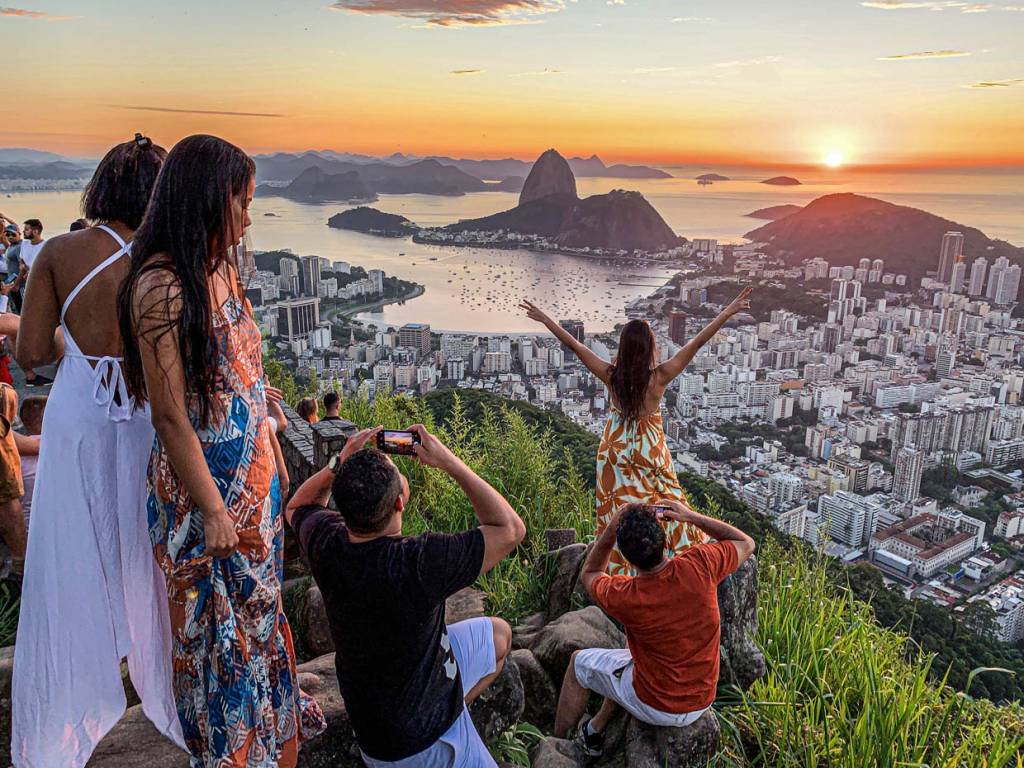 As pessoas aproveitam o nascer do sol no mirante Dona Marta, com o Pão de Açúcar ao fundo, em meio ao surto da doença do coronavírus (COVID-19), no Rio de Janeiro, Brasil, 31 de dezembro de 2020. REUTERS / Sergio Queiroz