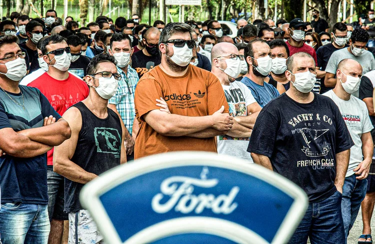 Trabalhadores com máscaras faciais participam de assembleia geral com sindicato em frente a fábrica da Ford Motor Co, após a empresa anunciar que fechará suas três fábricas no país, em Taubaté, Brasil, em 12 de janeiro de 2021.  (Carla Carniel/Reuters)
