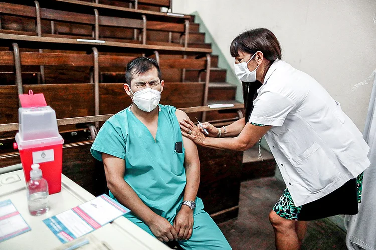 Profissional de saúde recebe dose da Sputnik V na Argentina: Brasil espera receber 10 milhões de doses prontas da vacina, além da fabricação nacional (Agustin Marcarian/Reuters)