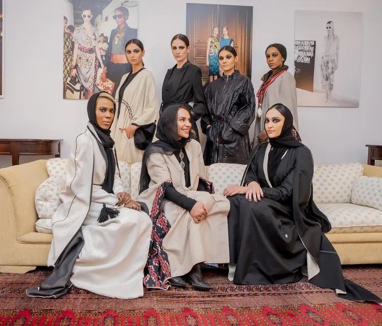 A diretora de criação Princesa Safia Hussein Guerras (sentada ao centro), a Princesa Hannah Al-Faisal (à direita) e as modelos após o desfile. (Basheer Saleh/Divulgação)