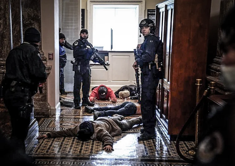 A polícia do Capitólio detém manifestantes do lado de fora da Câmara da Câmara durante uma sessão conjunta do Congresso em 6 de janeiro de 2021 em Washington, DC. O Congresso realizou uma sessão conjunta hoje para ratificar a vitória do Colégio Eleitoral 306-232 do presidente eleito Joe Biden sobre o presidente Donald Trump. Um grupo de senadores republicanos disse que rejeitaria os votos do Colégio Eleitoral de vários estados, a menos que o Congresso indicasse uma comissão para auditar os resultados das eleições (Drew Angerer/Getty Images)