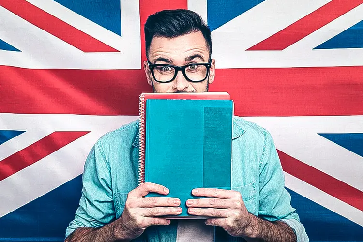 Homem estudando inglês na frente da bandeira do Reino Unido (Deagreez/Getty Images)