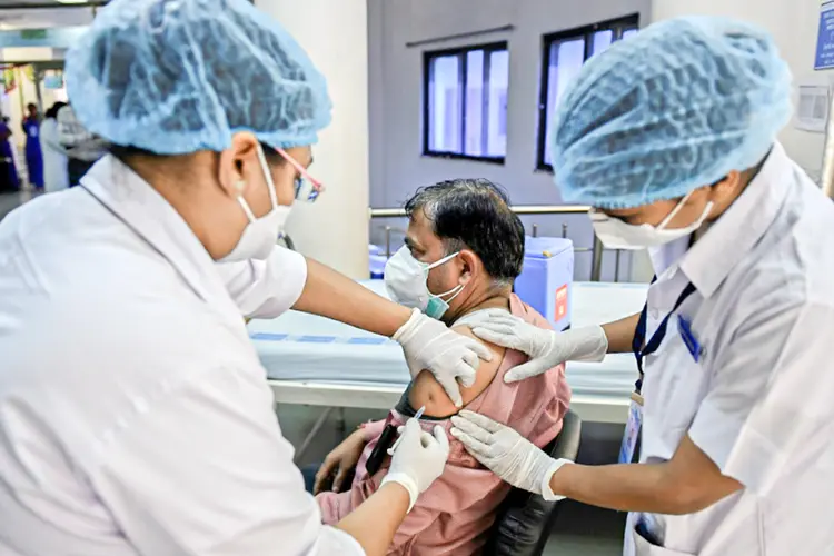 Vacinação: Enfermeiro vacina um médico contra a covid-19 em Ahmedabad, noroeste da Índia (AFP/AFP)