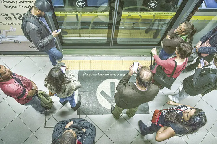 Pessoas com celular no metrô: com o mundo mais conectado, a digitalização deixou de ser opcional (Danilo Verpa/Folhapress)