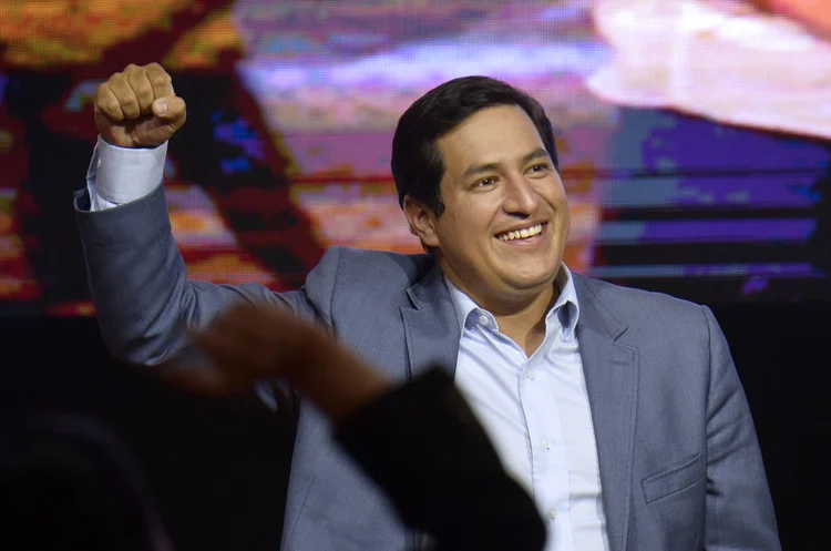 Ecuadorian presidential candidate for the Union por la Esperanza party Andres Arauz raises his clenched fist during a press conference following general elections in Quito, Ecuador, on February 7, 2021. - Leftist economist Andres Arauz claimed "a resounding victory" as exit polls predicted he would face right-wing ex-banker Guillermo Lasso in a runoff after polls closed Sunday in Ecuador's general election. (Photo by RODRIGO BUENDIA / AFP) (RODRIGO BUENDIA / AFP/AFP)