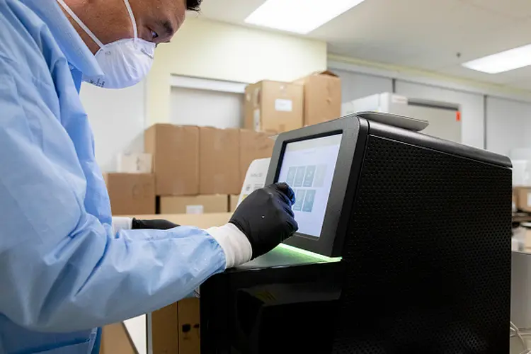 Profissional em laboratório com equipamento da Illumina: demanda em alta para identificação de mutação do novo coronavírus (San Francisco Chronicle/Hearst Newspapers via Getty Images/Getty Images)