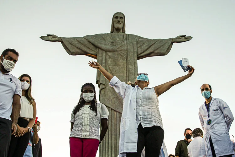 Dulcineia da Silva Lopes gesticula próximo a Teresinha Conceição após receber a vacina contra o coronavírus Sinovac (COVID-19) na estátua do Cristo Redentor no Rio de Janeiro, Brasil 18 de janeiro de 2021.  (Ricardo Moraes/Reuters)