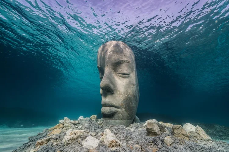 Uma das seis esculturas de rostos divididos ao meio. (Jason deCaires Taylor/Reprodução)