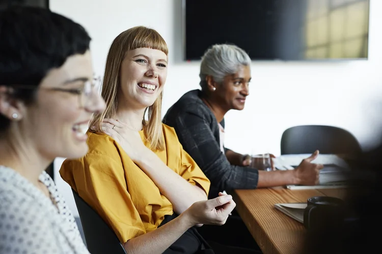 Smiling entrepreneur with female coworker looking away in meeting at workplace (Klaus Vedfelt)