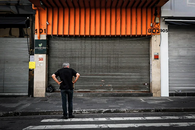 Pedestre observa loja fechada no centro de São Paulo por restrições em combate ao novo coronavírus (Amanda Perobelli/Reuters)