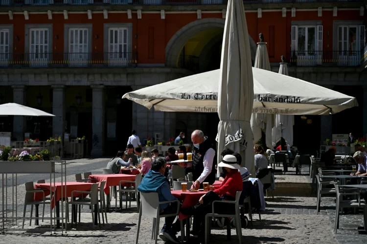 Pessoas desfrutam de um dia de sol em um terraço na Plaza Mayor em Madri, em 25 de março de 2021 (AFP/AFP)