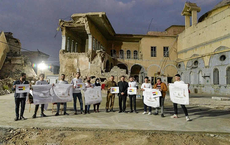 Voluntários na visita do Papa em Mossul em frente à igreja destruída na guerra contra o terrorismo (Zaid AL-OBEIDI/Getty Images)