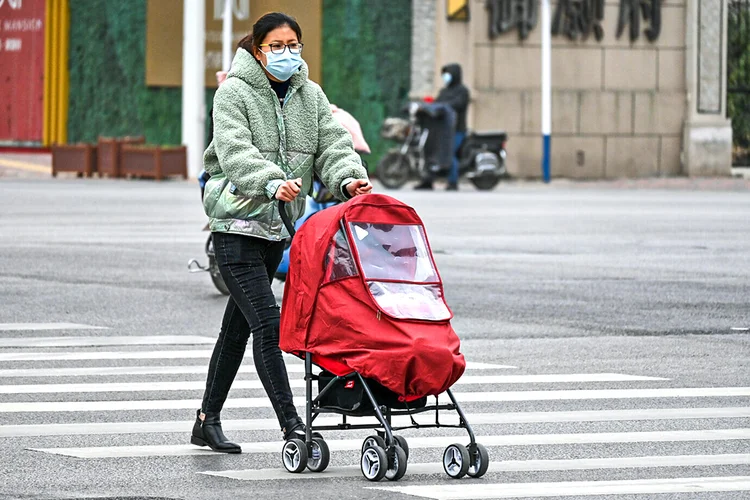Mulher com máscara na província de Hebei, na China: a lenta imunização ameaça minar a vantagem conseguida ao controlar o coronavírus de maneira eficaz (Oriental Image via Reuters Connect/Reuters)