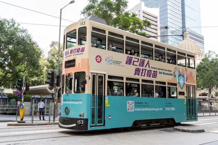 Um bonde com um anúncio do programa de vacinas viaja ao longo de uma estrada em Hong Kong. (Bloomberg/Bloomberg)