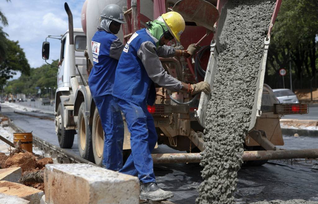 Operários trabalham com caminhão de cimento em obra | Foto: Washington Alves/Reuters (Washington Alves/Reuters)