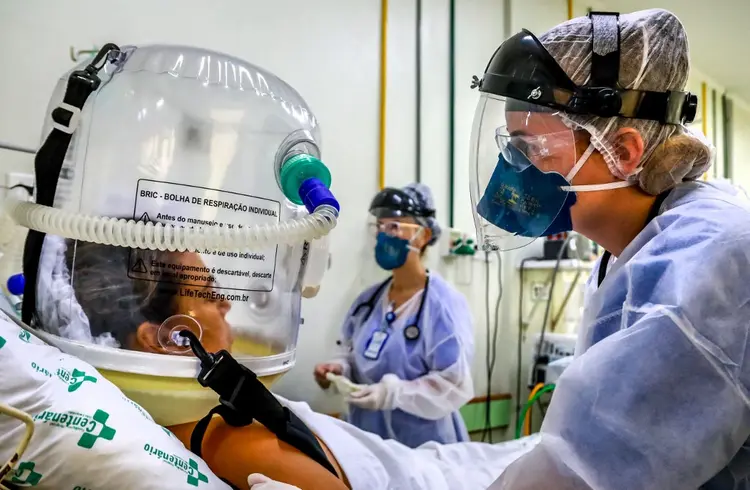 Paciente com covid-19 e profissionais da saúde do Hospital em São Leopoldo, Rio Grande do Sul (SILVIO AVILA/AFP)