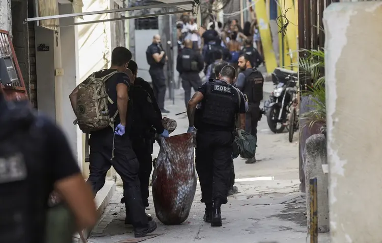 Policiais carregam corpo durante operação na favela do Jacarezinho (Ricardo Moraes/Reuters)