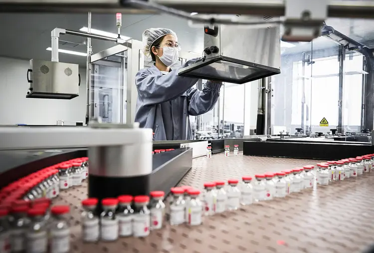 Funcionário trabalha na linha de produção da vacina de dose única contra a covid-19 da CanSino em Tianjin, China. (China Daily/Reuters)