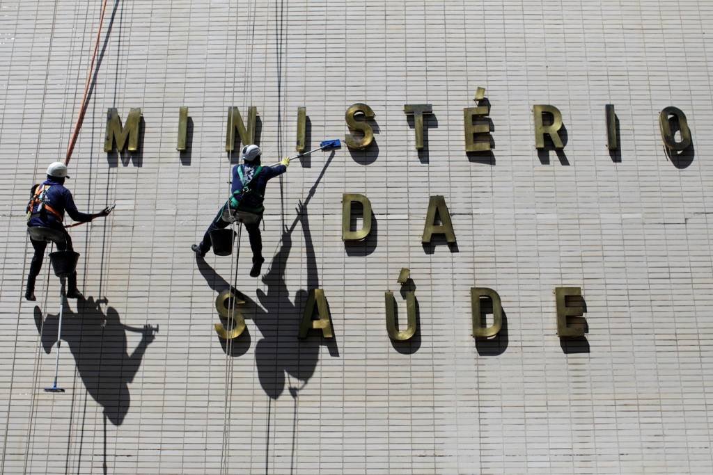 Funcionários limpam fachada do prédio do Ministério da Saúde (Ueslei Marcelino/Reuters)