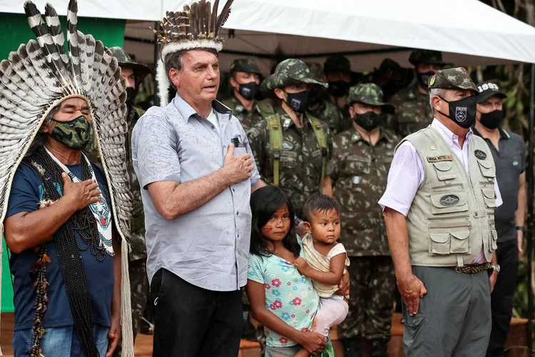 Jair Bolsonaro: presidente ouve o hino nacional em visita a terras indígenas, no Amazonas. (Marcos Correa/Divulgação/Reuters)