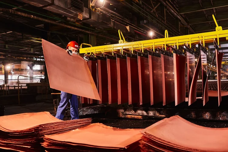 Um trabalhador manuseia chapas catódicas de cobre recém-formadas em um depósito na planta de fundição de cobre da KGHM Polska Miedz SA em Glogow, Polônia, na terça-feira, 9 de março de 2021. O níquel estendeu sua queda de seis anos após uma queda no mercado de ações. apetite de risco, enquanto o cobre retomou as perdas à medida que as preocupações com a oferta diminuíram (Bartek Sadowski/Bloomberg)