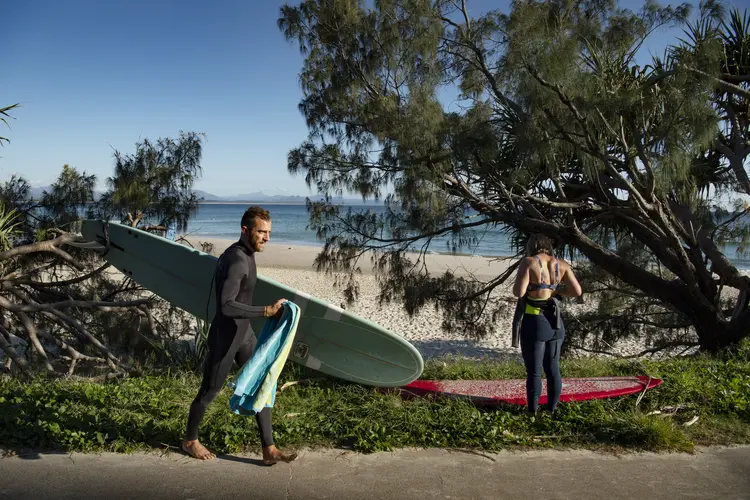 Surfistas em Byron Bay, Austrália. Nos últimos anos, a outrora pacata cidade litorânea se tornou um destino mundialmente conhecido. (Matthew Abbott/The New York Times)