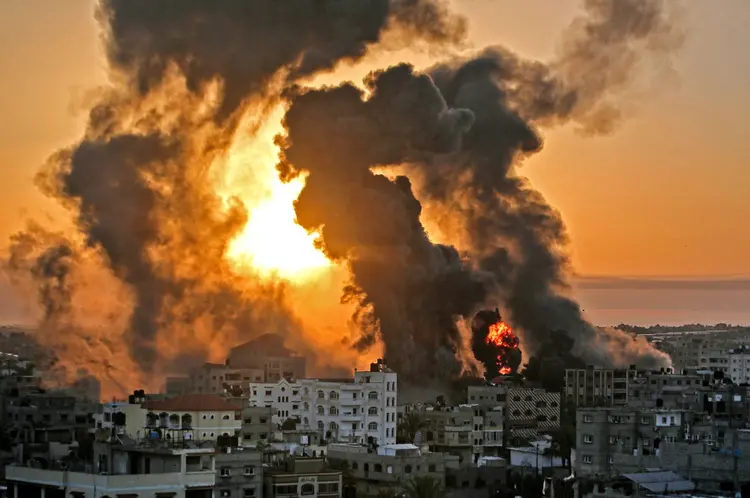Os ataques aéreos israelenses na Faixa de Gaza atingiram as casas de membros do alto escalão do grupo militante Hamas, disseram os militares na quarta-feira, com o quartel-general da polícia do território também como alvo. (YOUSSEF MASSOUD/AFP)