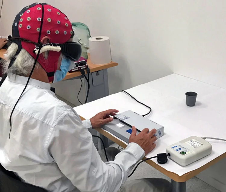 Montagem experimental, onde o voluntário foi solicitado a dizer se o copo estava ou não sobre a mesa branca. As respostas comportamentais e a atividade cerebral foram registradas simultaneamente (Nature Medicine/Reprodução)