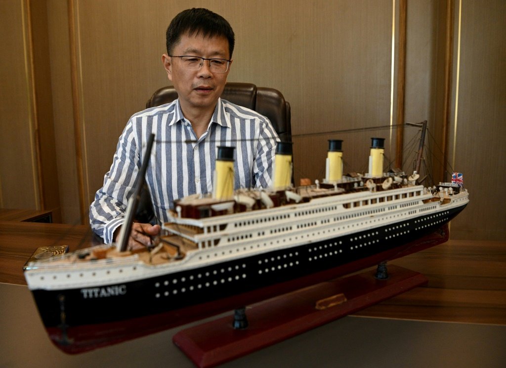 Su Shaojun diante de uma maquete do Titanic, em seu escritório em Daying, China, em 26 de abril de 2021 (Reprodução/AFP)