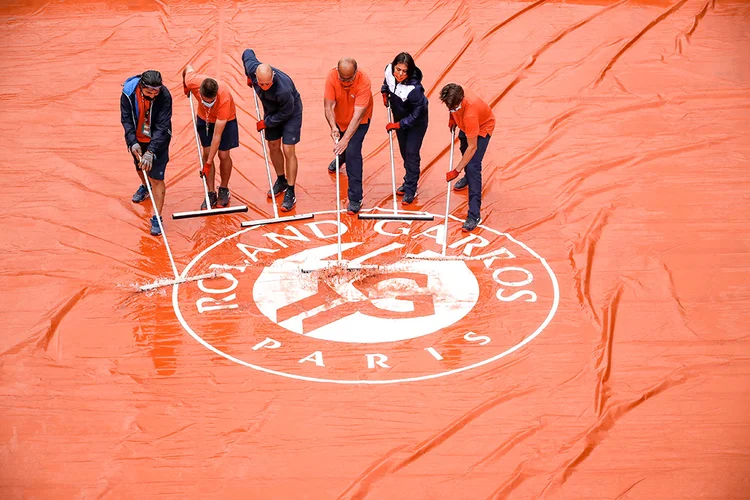 Funcionários secam quadra de Roland Garros. (Christian Hartmann/Reuters)