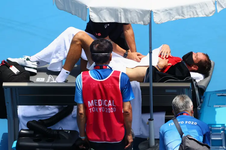 Tenista russo Daniil Medvedev recebe atendimento médico após sentir-se mal durante partida contra o italiano Fabio Fognini na Olimpíada de Tóquio. (Mike Segar/Reuters)