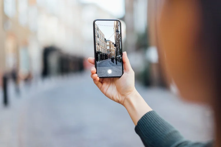 Close-up shot of woman photographing the European street view in London using smartphone. (Getty Images/Getty Images)