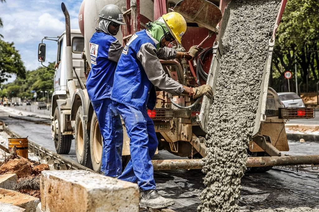 Operários trabalham com caminhão de cimento em obra (Reuters/Washington Alves)