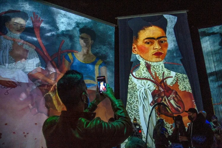 Um homem tira uma foto durante a abertura da exposição "Frida, a experiência imersiva" na Cidade do México. (Natalia Cano/AFP)