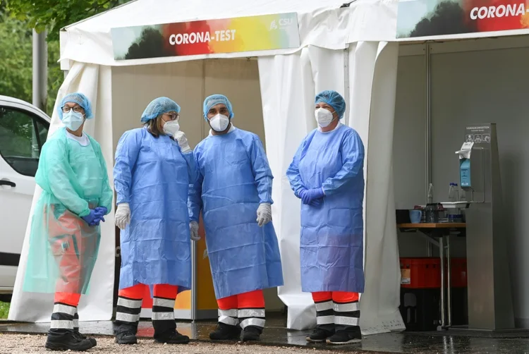 Pessoal de saúde espera em ponto de testes de detecção do coronavírus em Seeon-Seebruck, sul da Alemanha, em 14 de julho de 2021 (Foto/AFP)
