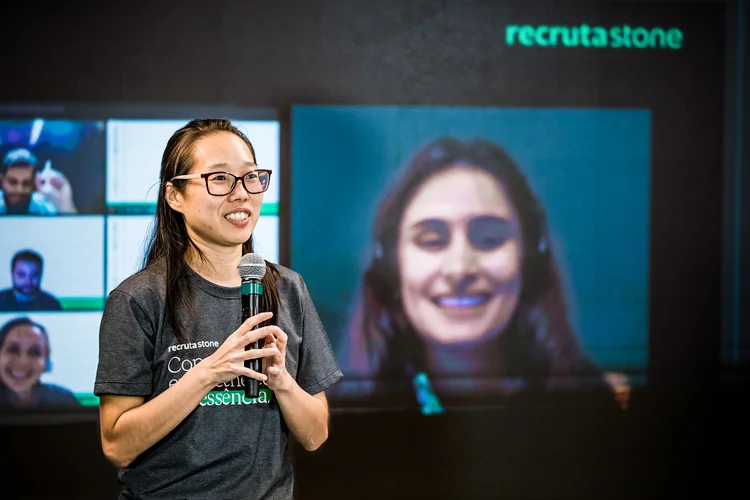 Livia Kuga, responsável pelo programa Recruta Stone, e vencedora da edição do primeiro semestre de 2021, Luiza Dias (na tela), que hoje está na equipe de Marketing da Ton (Stone/Divulgação)