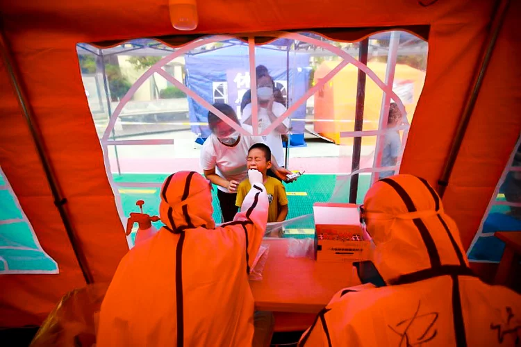 Profissional de saúde faz teste de Covid-19 em morador de Yangzhou, na China. (China Daily/Reuters)