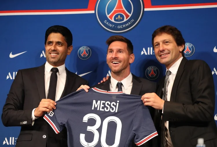 Lionel Messi mostra camisa que usará no Paris St Germain ao lado do presidente do clube, Nasser Al-Khelaifi, e do diretor esportivo do PSG, Leonardo. (Sarah Meyssonnier/Reuters)