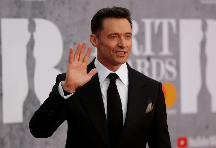 Ator Hugh Jackman acena e posa para fotos ao chegar para o Brit Awards em Londres. (Peter Nicholls/Reuters)