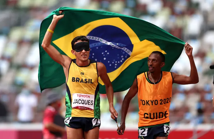 Yeltsin Jacques e seu guia Carlos Antonio dos Santos comemoram a 100ª medalha de ouro do Brasil em Jogos Paralímpicos, com recorde mundial nos os 1500 metros da classe T11 (Kiyoshi Ota / Correspondente/Getty Images)