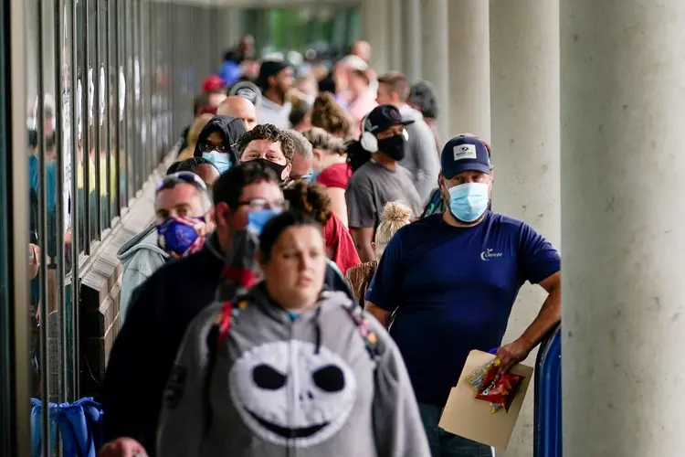 Pessoas fazem fila em centro de carreiras de Kentucky, nos EUA, em busca de assistência com pedidos de auxílio-desemprego. (Bryan Woolston/Reuters)