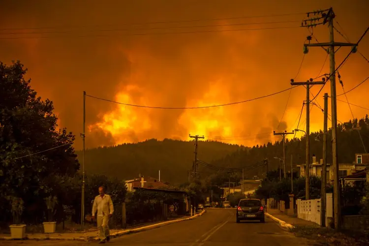 Ao menos 570 bombeiros trabalham na ilha, com auxílio de equipamentos enviados pela União Europeia (ANGELOS TZORTZINIS/afp/Getty Images)