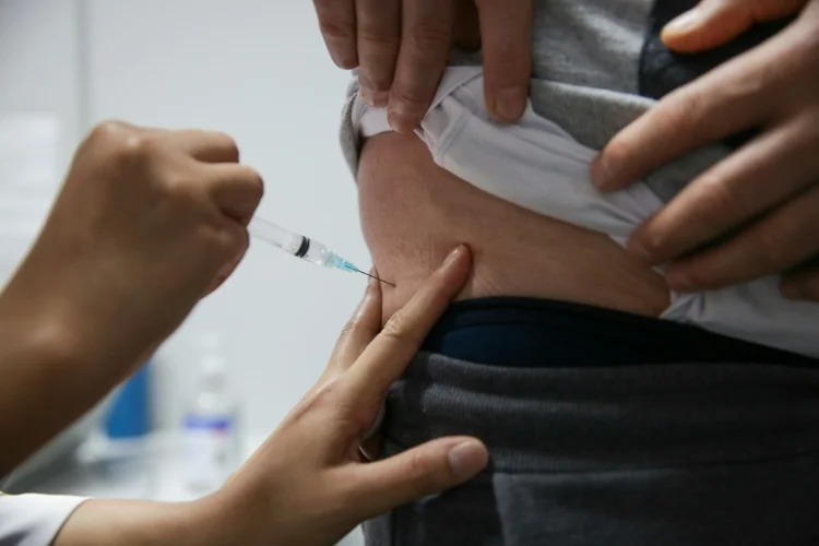 Homem recebe dose da vacina anticovid da Pfizer-BioNTech no centro de eventos Cau Hansen em Joinville, Santa Catarina (Reprodução/AFP)