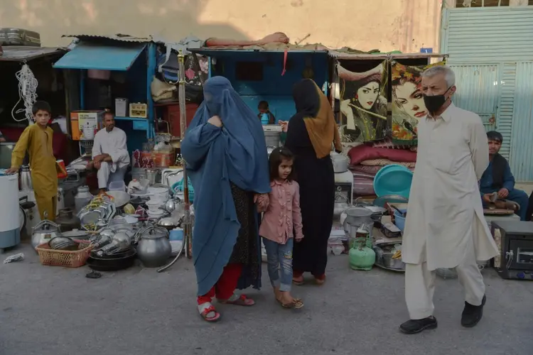 Mulher caminha em mercado de Cabul vestida com uma burca: temor de retrocesso de direitos com Talibã no poder. (AFP/AFP)
