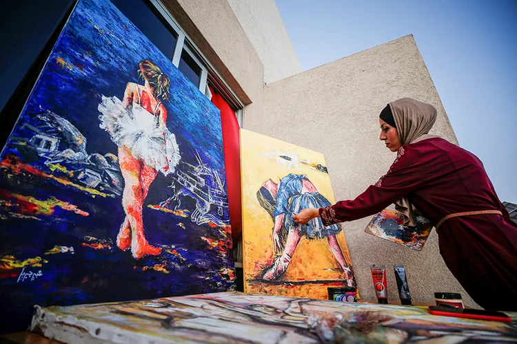 Artista palestina Abeer Jibril trabalha em suas pinturas de bailarina na Cidade de Gaza. (Mohammed Salem/Reuters)