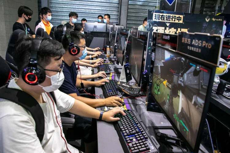 SHANGHAI, CHINA - JULY 31: People play online games at the booth of Huya, a Chinese live-streaming platform for video games and e-sports, during the 19th China Digital Entertainment Expo &amp; Conference (ChinaJoy) at Shanghai New International Expo Centre on July 31, 2021 in Shanghai, China. (Photo by VCG/VCG via Getty Images) (VCG/Getty Images)