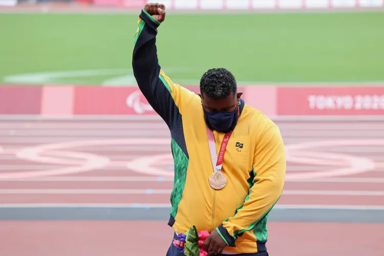Thiago Paulino protesta no pódio ao receber o bronze após apelação da China no arremesso de peso (Takuma Matsushita/CPB/Divulgação)