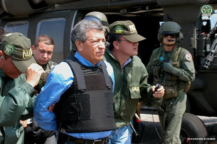 Miguel Rodríguez Orejuela, cofundador do Cartel de Cali, é transferido pela polícia colombiana para ser entregue em extradição às autoridades americanas, em 11 de março de 2005, na base aérea de Palanquero, Colômbia (Reprodução/AFP)