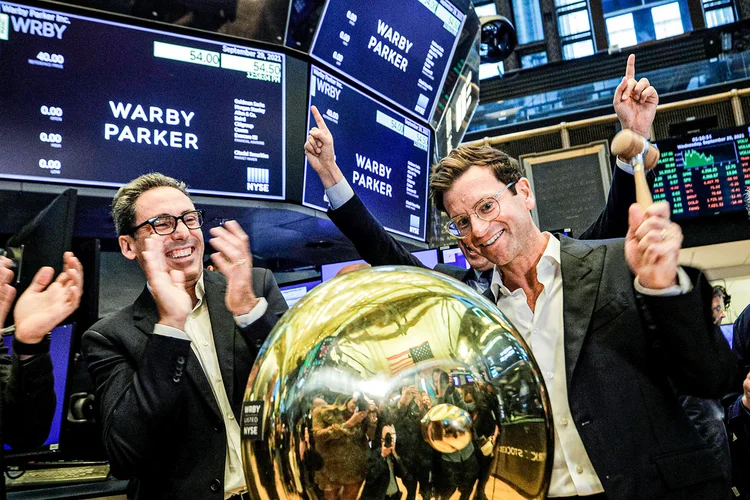 Os fundadores e co-CEOs Neil Blumenthal (à esq.) e Dave Gilboa, da Warby Parker, tocam o sino para a estreia na Bolsa de Nova York | Foto: Brendan McDermid/Reuters (Brendan McDermid/Reuters)